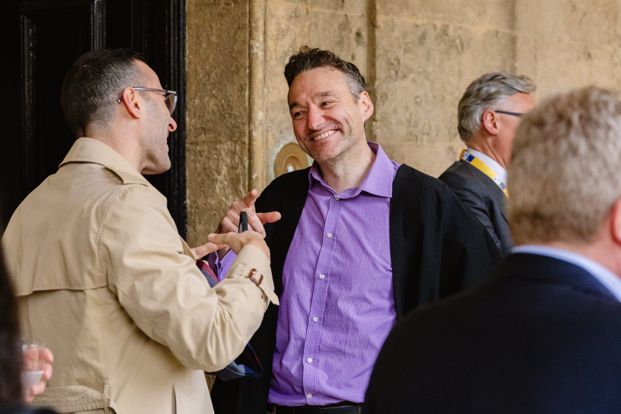Guest smiling and talking during a university college event in Oxford.